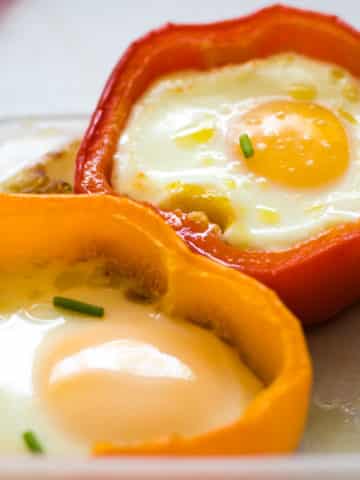 2 baked red and yellow bell pepper eggs in a hole served in a Tupperware