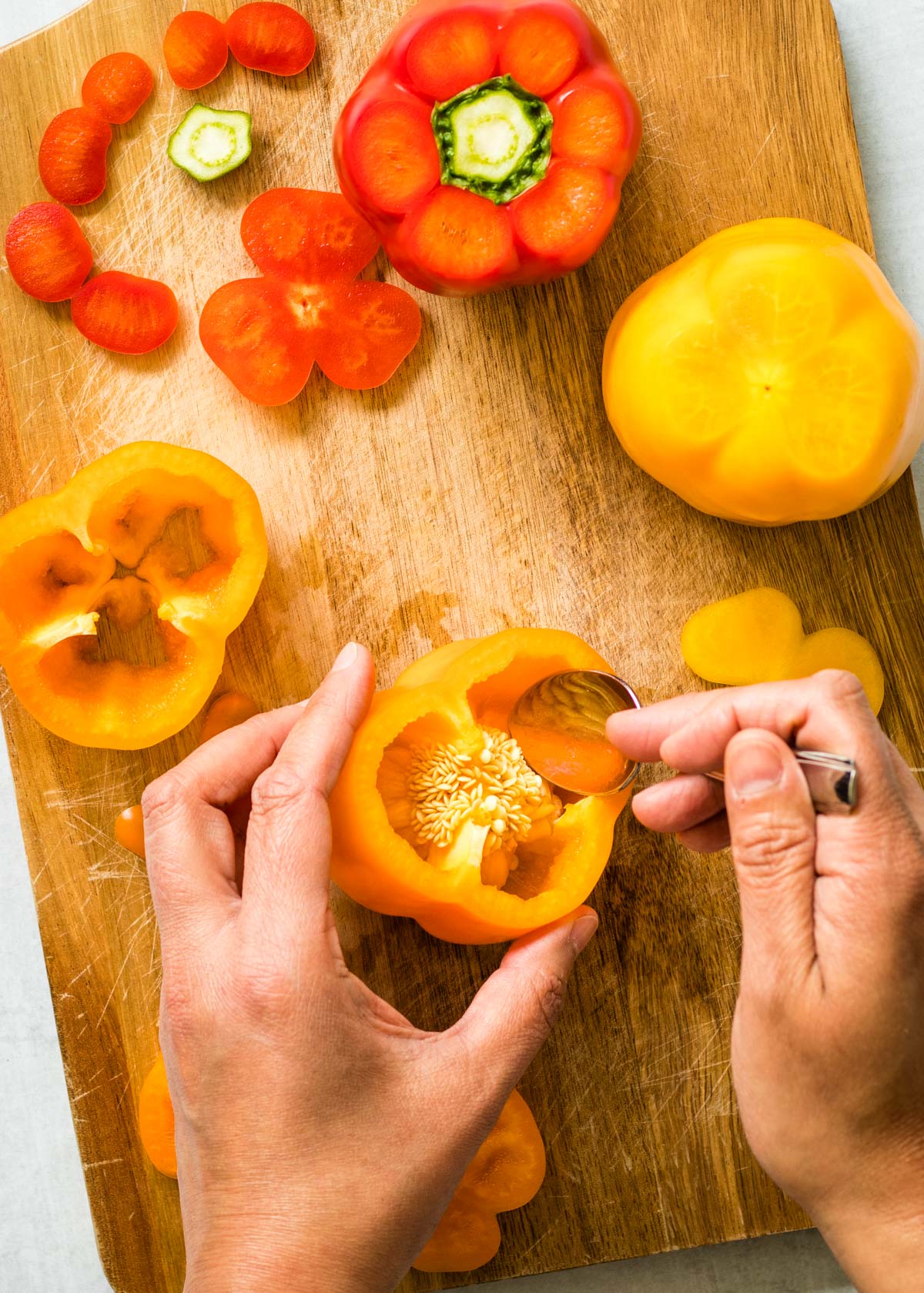 Use a spoon to scrape out the seeds and pulp from red and orange bell peppers.