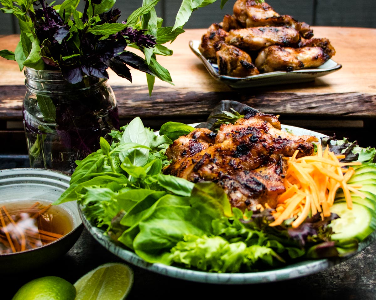 Serve lemongrass chicken wings on a bed of spring greens, herbs and carrots with a side of fish sauce