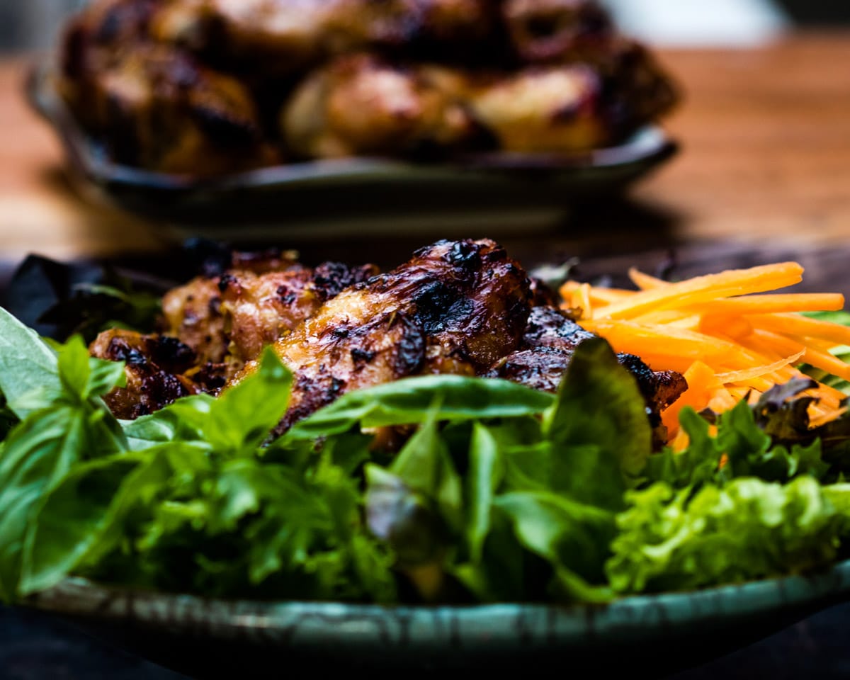 Tasty lemongrass chicken wings charred on the grill and served on a bed of veggies.