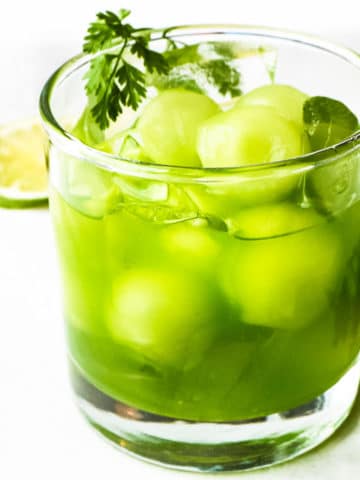 Iced matcha green tea with melon balls in a glass of ice