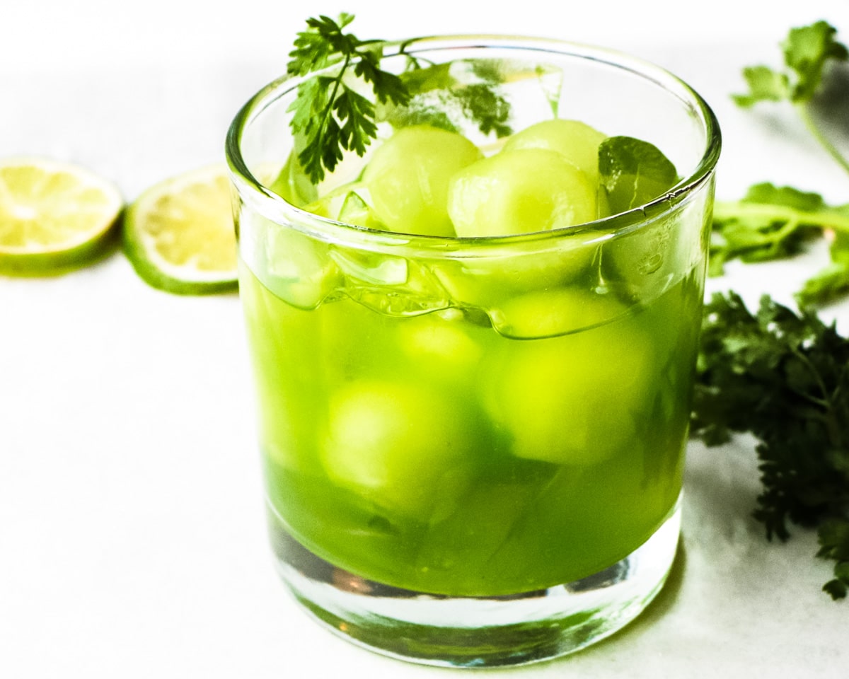 Iced matcha green tea with melon balls in glass of ice
