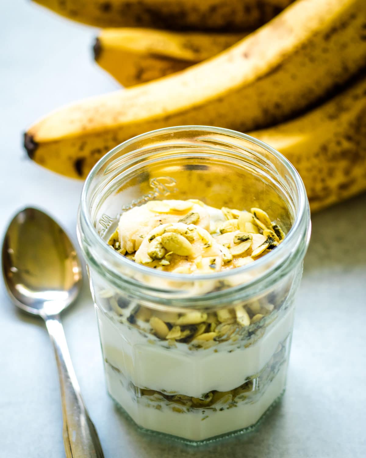 Yogurt parfait with banana and salted pumpkin seeds in a mason jar