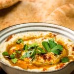 baba ghanoush in a serving bowl with pita bread