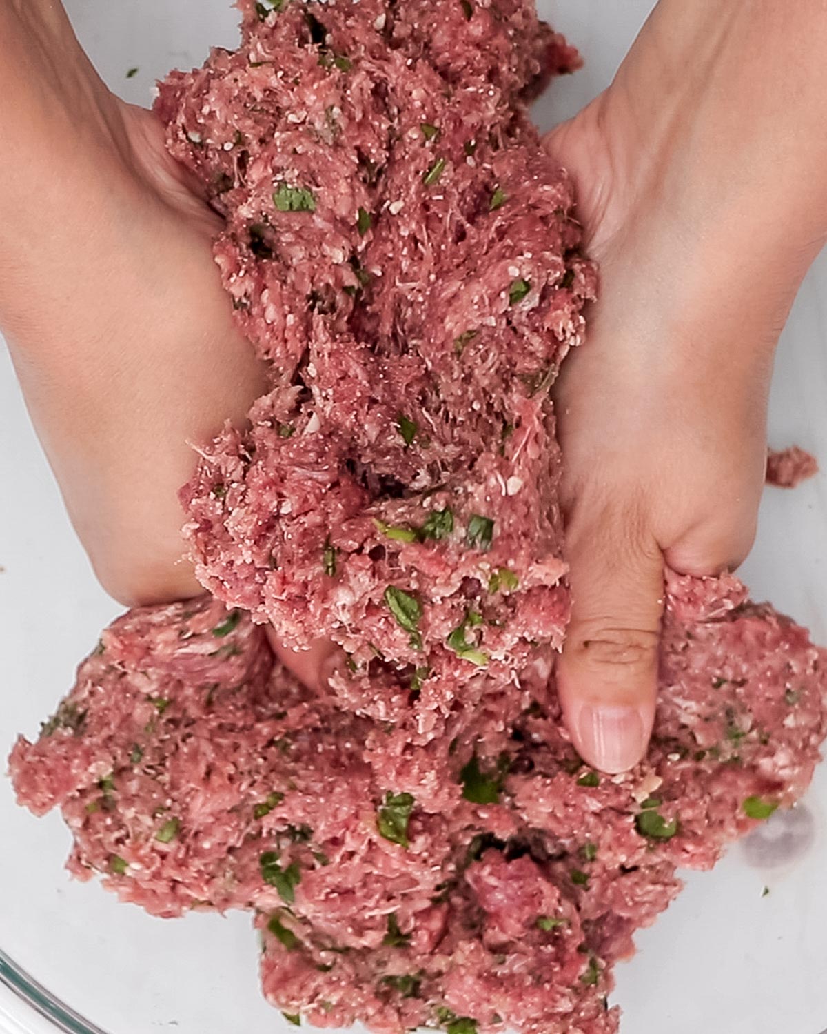 Mixing meatball ingredients by hand