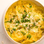 Spaghetti squash with butter, Parmesan cheese, parsley and black pepper in a ceramic bowl