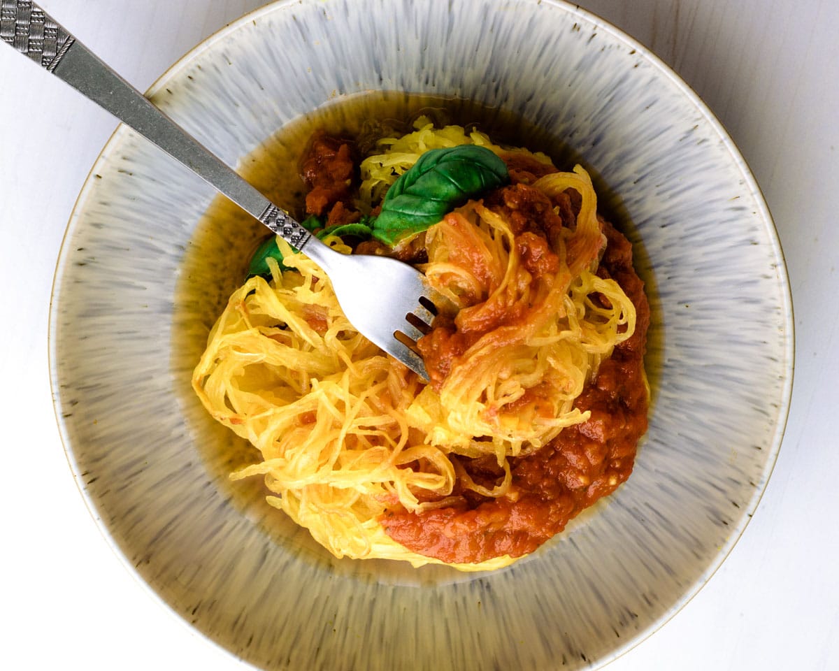 Air fryer spaghetti squash plated with pasta sauce and basil