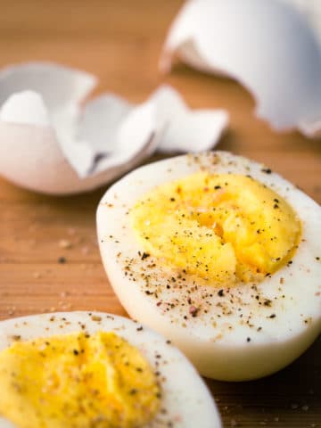 Perfectly smooth, easy to peel, steamed hard boiled eggs sliced in half with salt and pepper