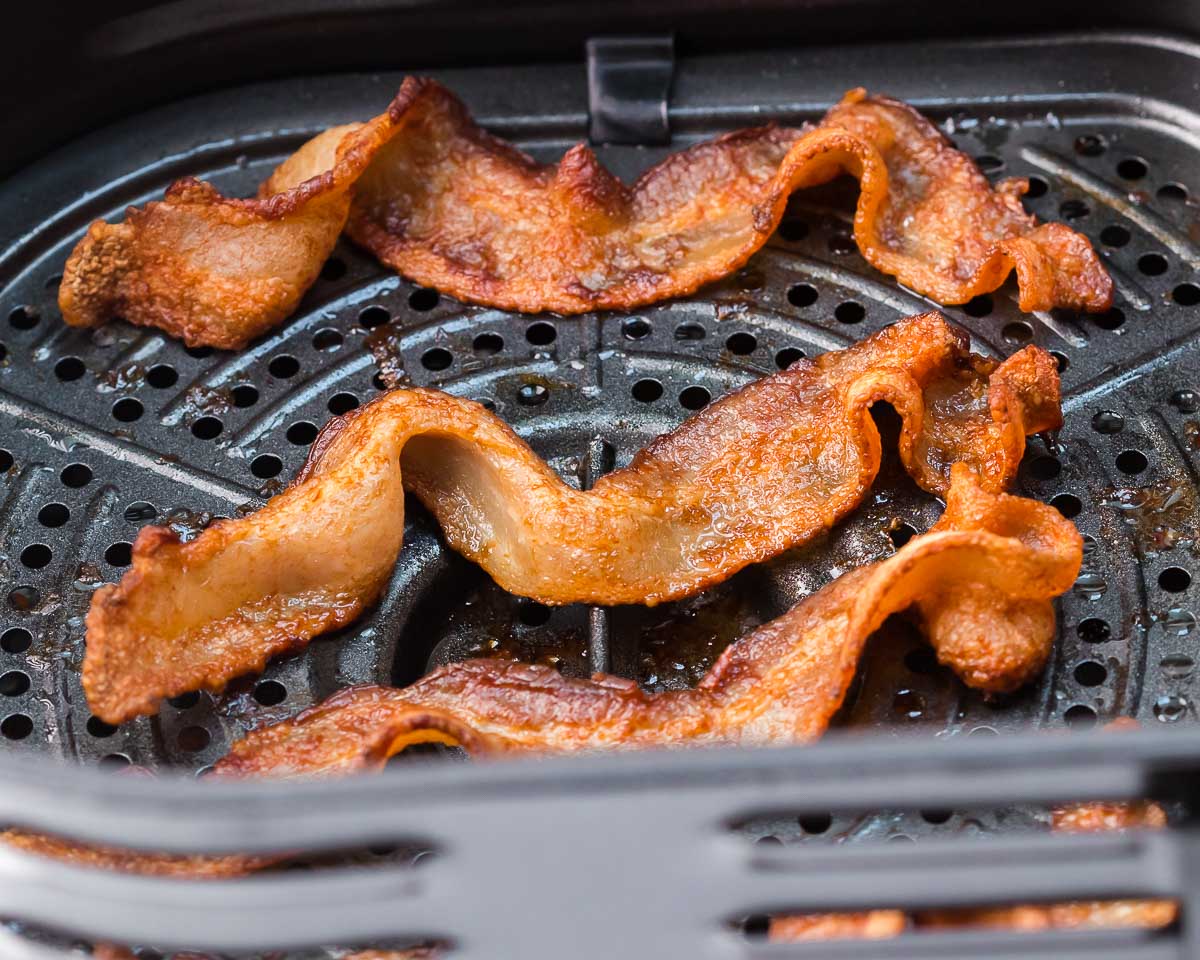 Air fryer bacon wide view of cooked bacon in air fryer basket
