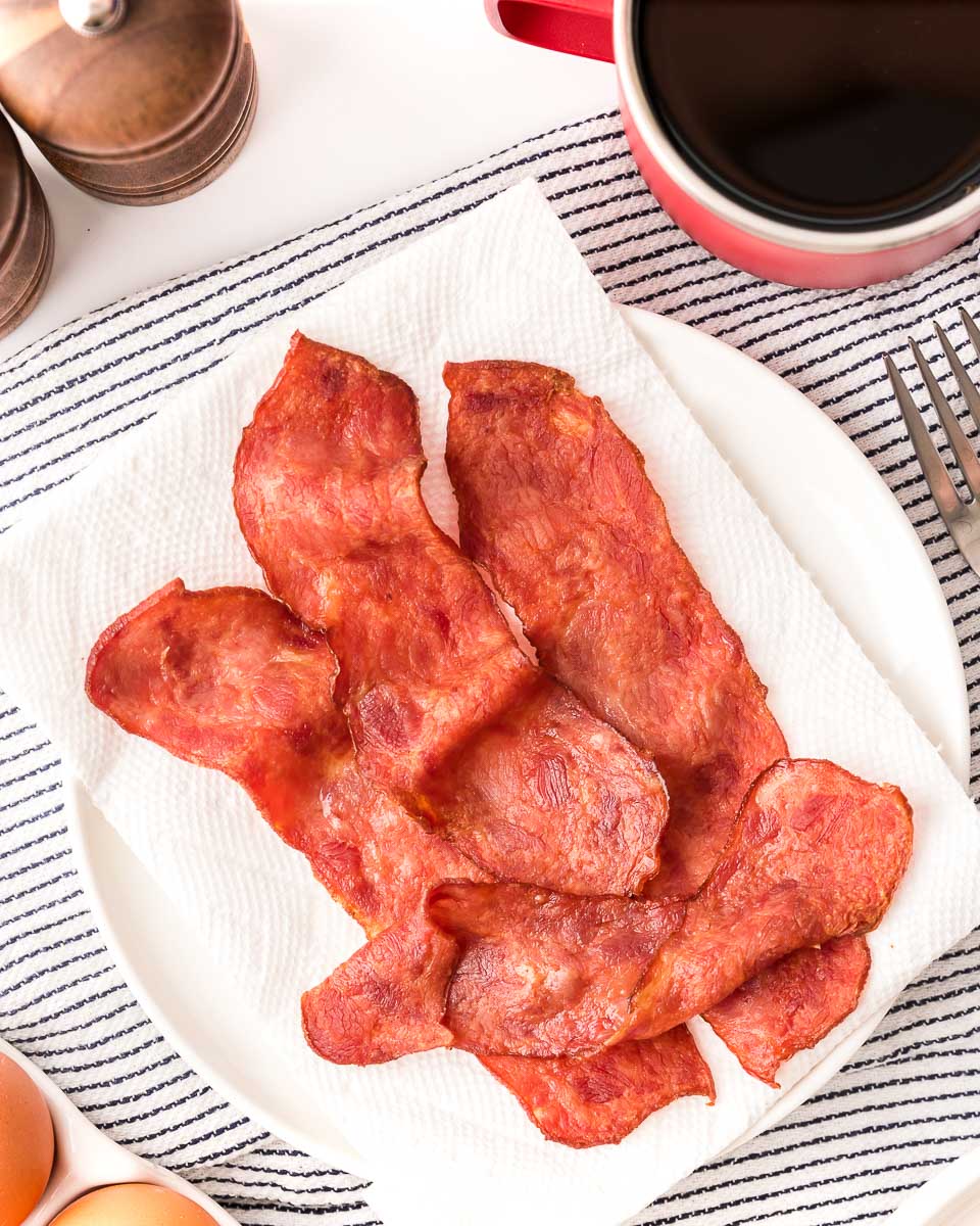 Air fryer turkey bacon served with coffee and eggs top view