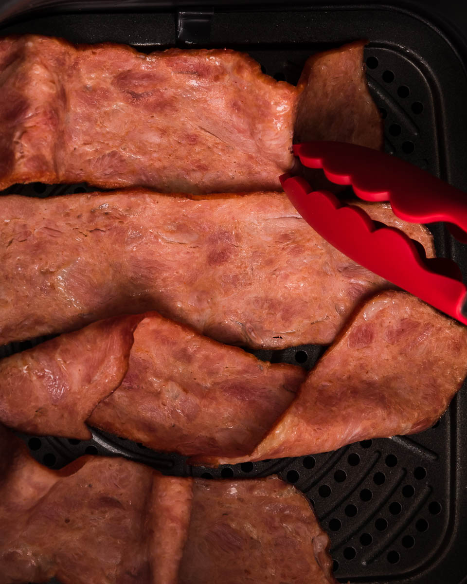 Air fryer turkey bacon step 3 shape with tongs