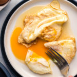 over easy eggs overhead with fork breaking yolk