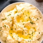 Cauliflower mashed potatoes overhead in serving bowl butter pepper chives