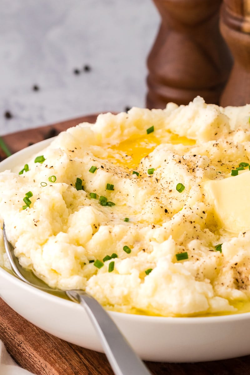 Cauliflower mashed potatoes spoon butter pepper chives serving tall 45