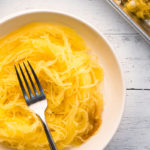 Baked spaghetti squash spaghetti noodles plated with fork