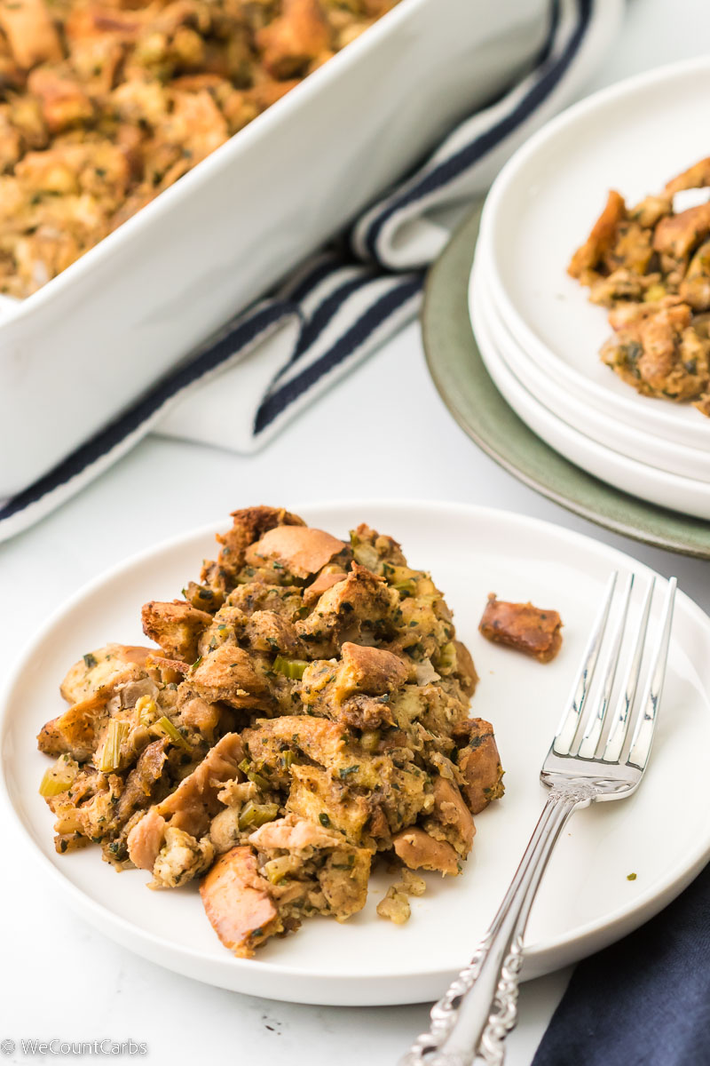 Keto stuffing served on plate with a fork and pan in the back